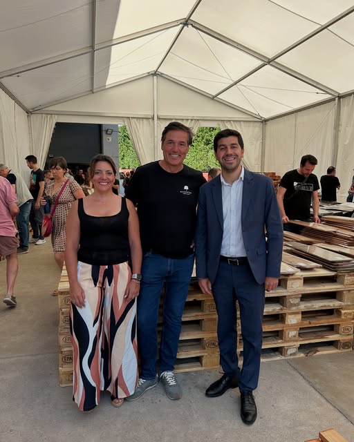 El Alcalde Sergio Yunquera y la primera teniente de alcalde Olga Romero, junto a un representante de Madinter, posando en la jornada de puertas abiertas de la empresa en El Boalo, Cerceda y Mataelpino, con maderas apiladas al fondo