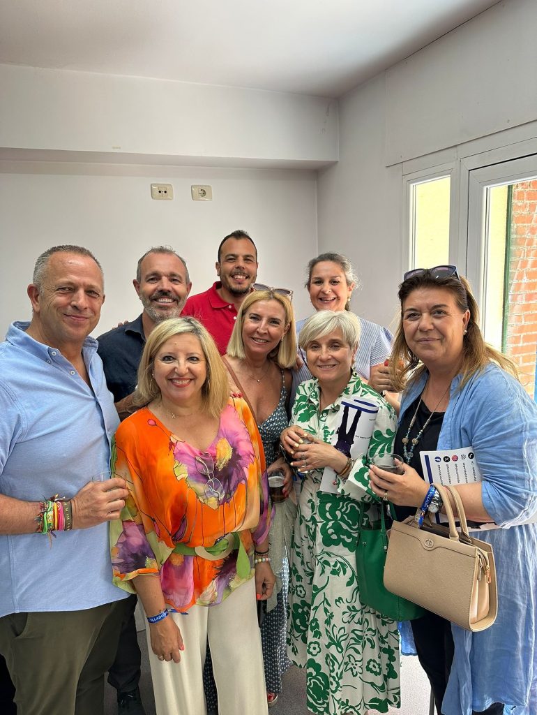 Un grupo de ocho afiliados y simpatizantes del Partido Popular, sonrientes, reunidos en un ambiente interior, mostrando el espíritu de comunidad y apoyo.