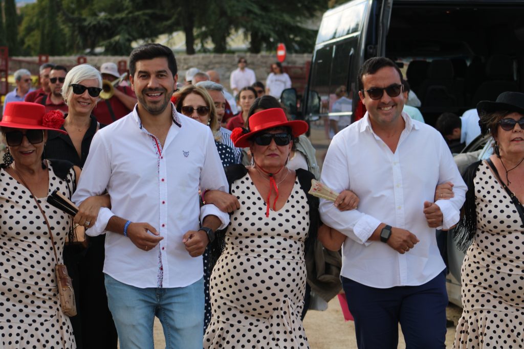 Un grupo de personas, incluyendo al Alcalde Sergio Yunquera, desfilando en una romería o procesión, con vestimentas tradicionales y sonrisas en sus rostros.